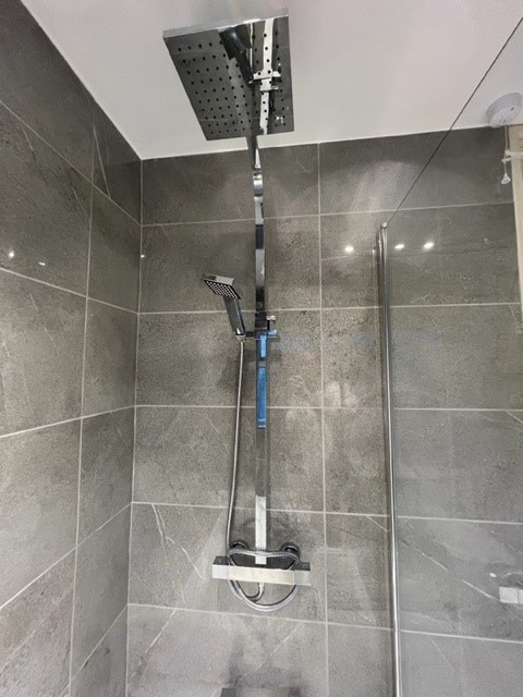 Tiled bathroom with square chrome dual outlet shower